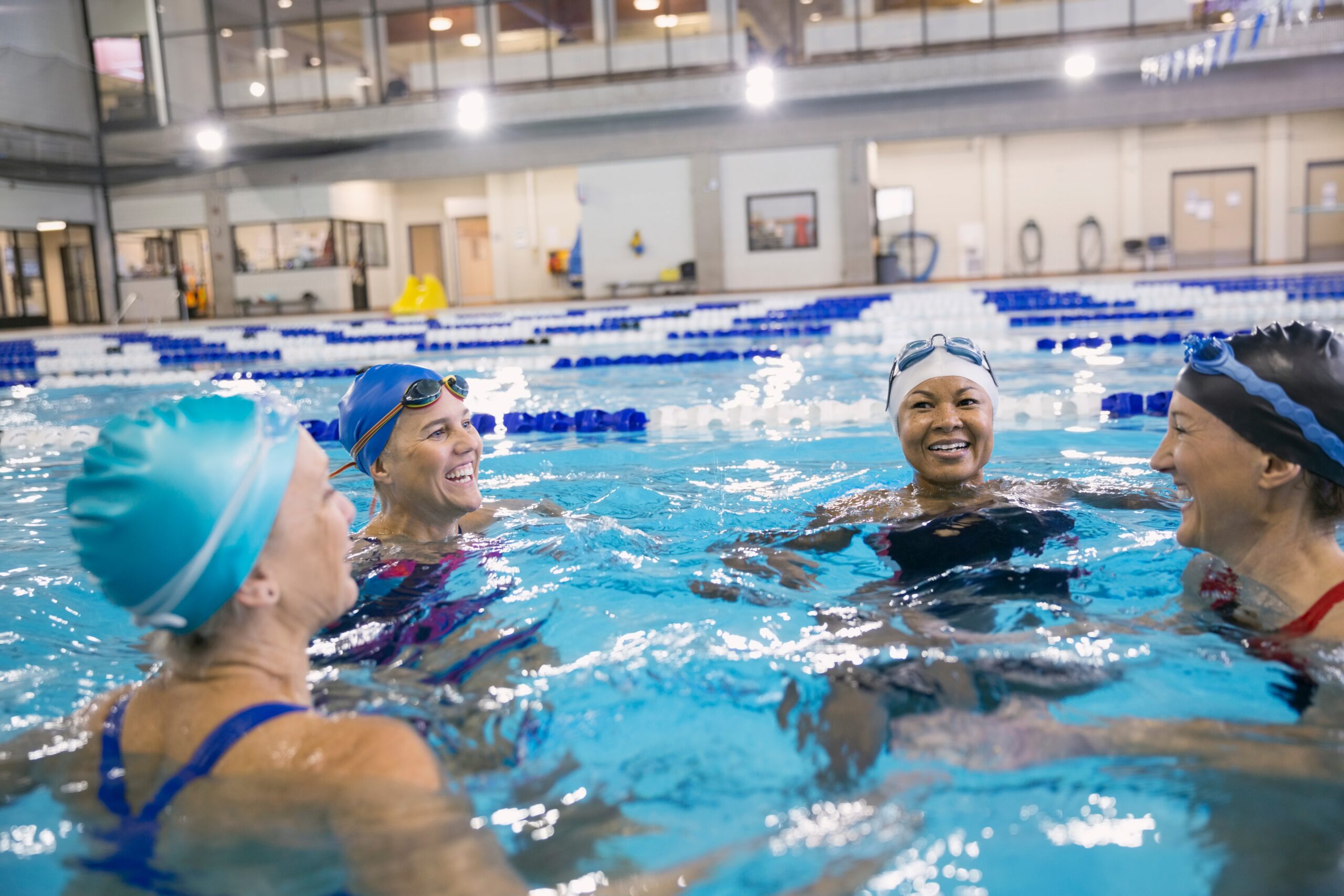 “Woman doing aquatic fitness workout in a swimming pool, demonstrating water aerobics exercises designed for strength, flexibility, and low-impact cardio training.”